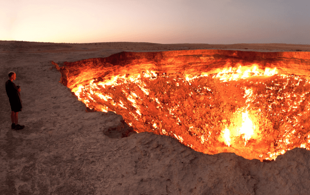 A Man Standing Next To "The Door To Hell"