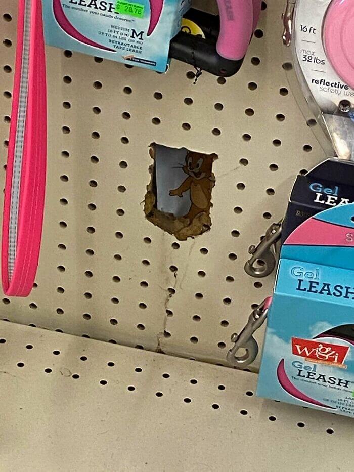 ジェリーはペットショップの壁に隠れている