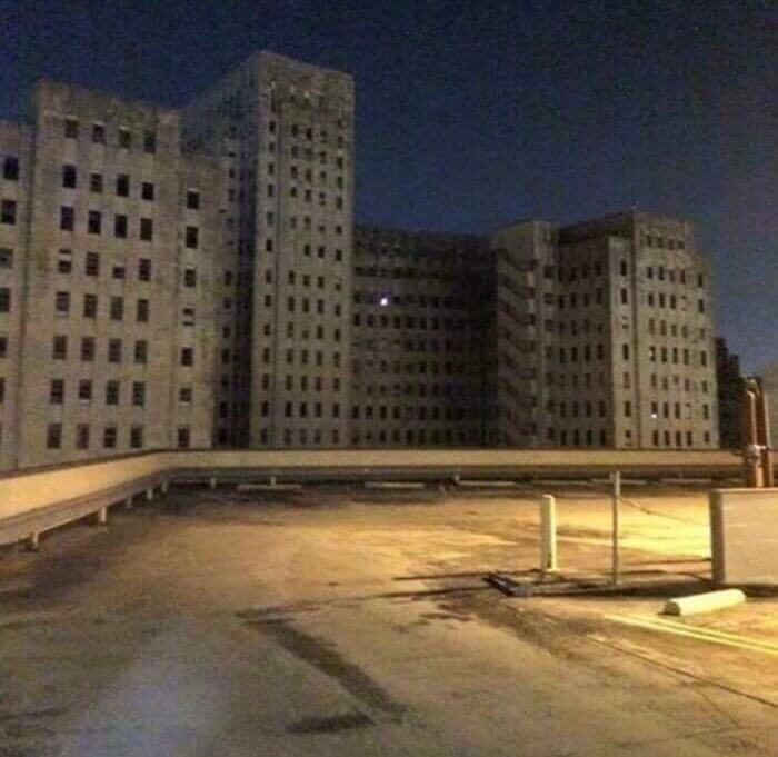 Uma janela acesa em um prédio hospitalar abandonado