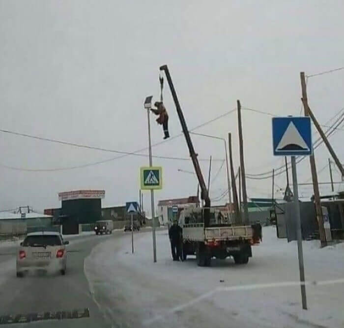 A Man Hanging From a Crane Hook