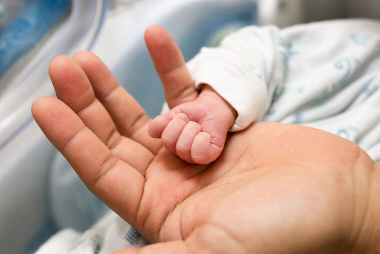 Newborn Baby's Fist Inside a Father's Palm