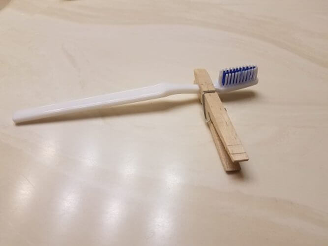 Use A Clothespin As A Toothbrush Holder
