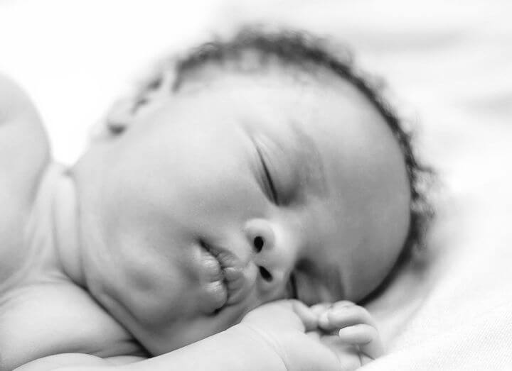 Holding Her Newborn In Her Arms