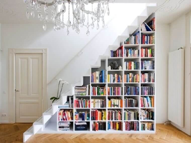 Une bibliothèque sous les escaliers économise de l'espace et ajoute de la couleur