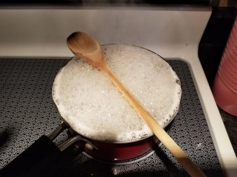 Laying a Wooden Spoon Over a Boiling Pot to Pop Bubbles and Prevent Starchy Messes
