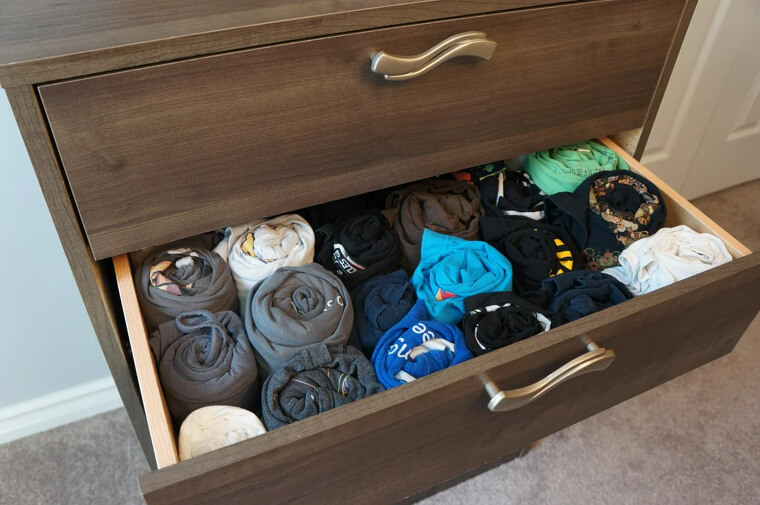 Um mehr Platz in deinen Schubladen zu schaffen, roll deine Kleidung auf