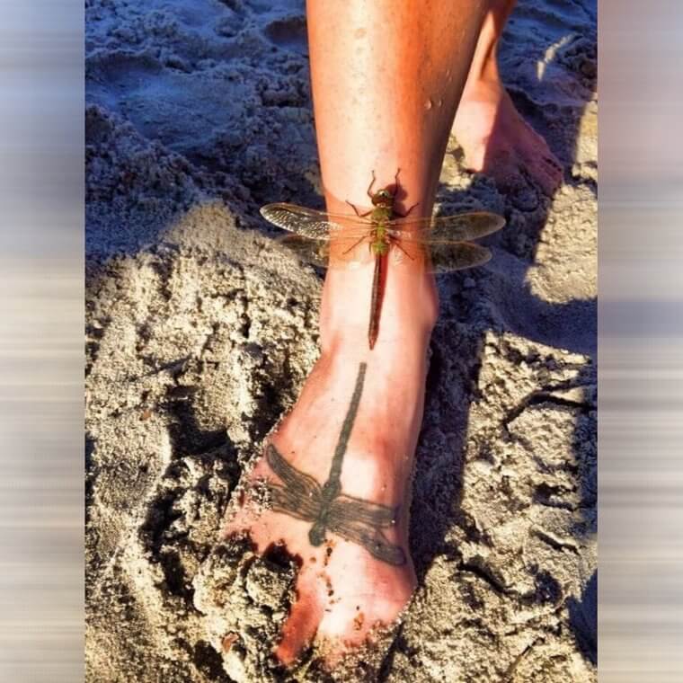 Een libelle landde naast een tatoeage van zichzelf
