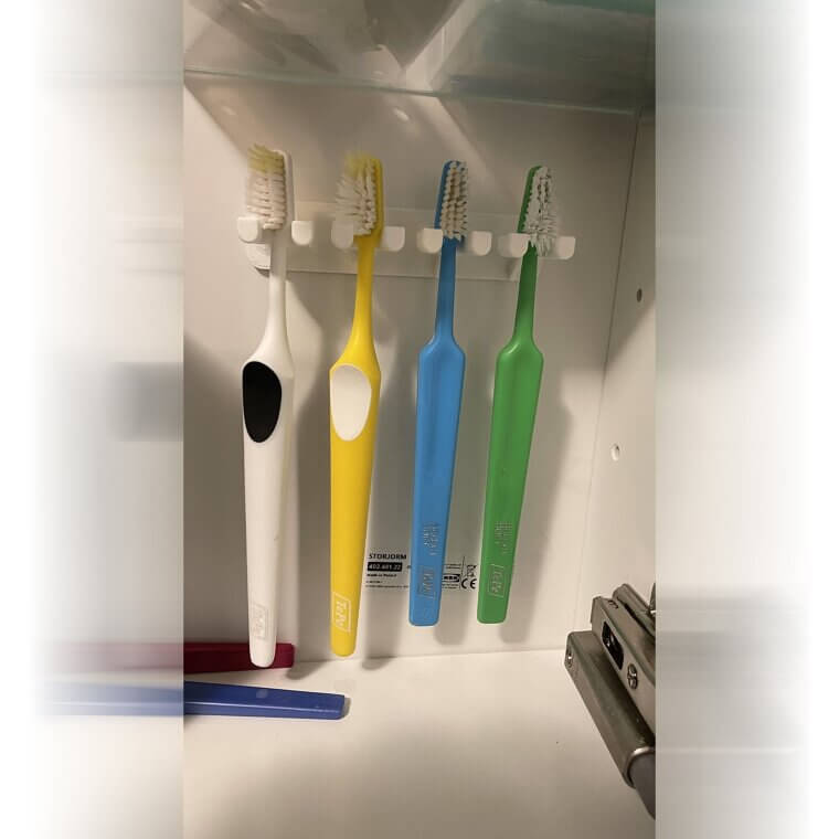 Use ganchos para pendurar escovas de dente