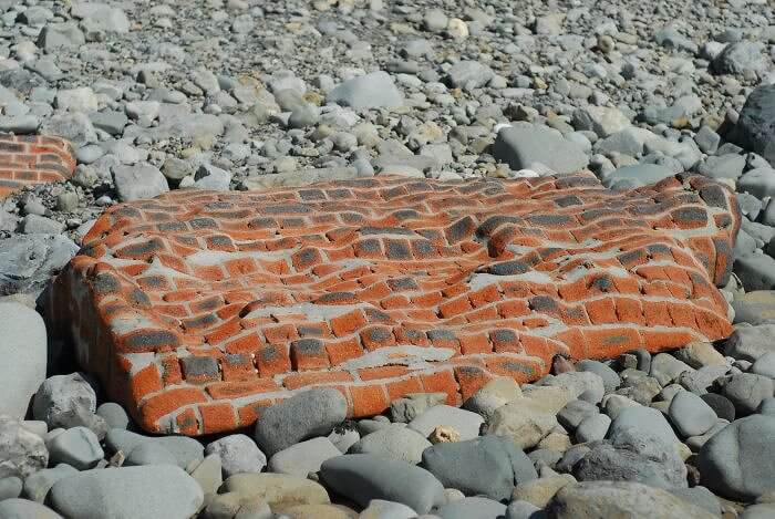 Een bakstenen muur blootgesteld aan de zee